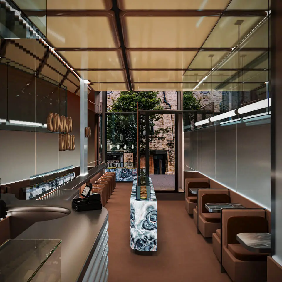 Cinnavibes Modern café interior with brown seating booths, a long patterned bar, reflective ceiling, and large windows showing trees and a stone building outside—the perfect setting to enjoy indulgent cinnamon rolls at Cinnavibes, the Cinnamon Desserts Café. Cinnamon Rolls